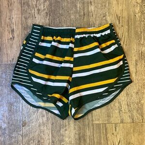 Green, yellow, and white Varsity shorts in a size XS